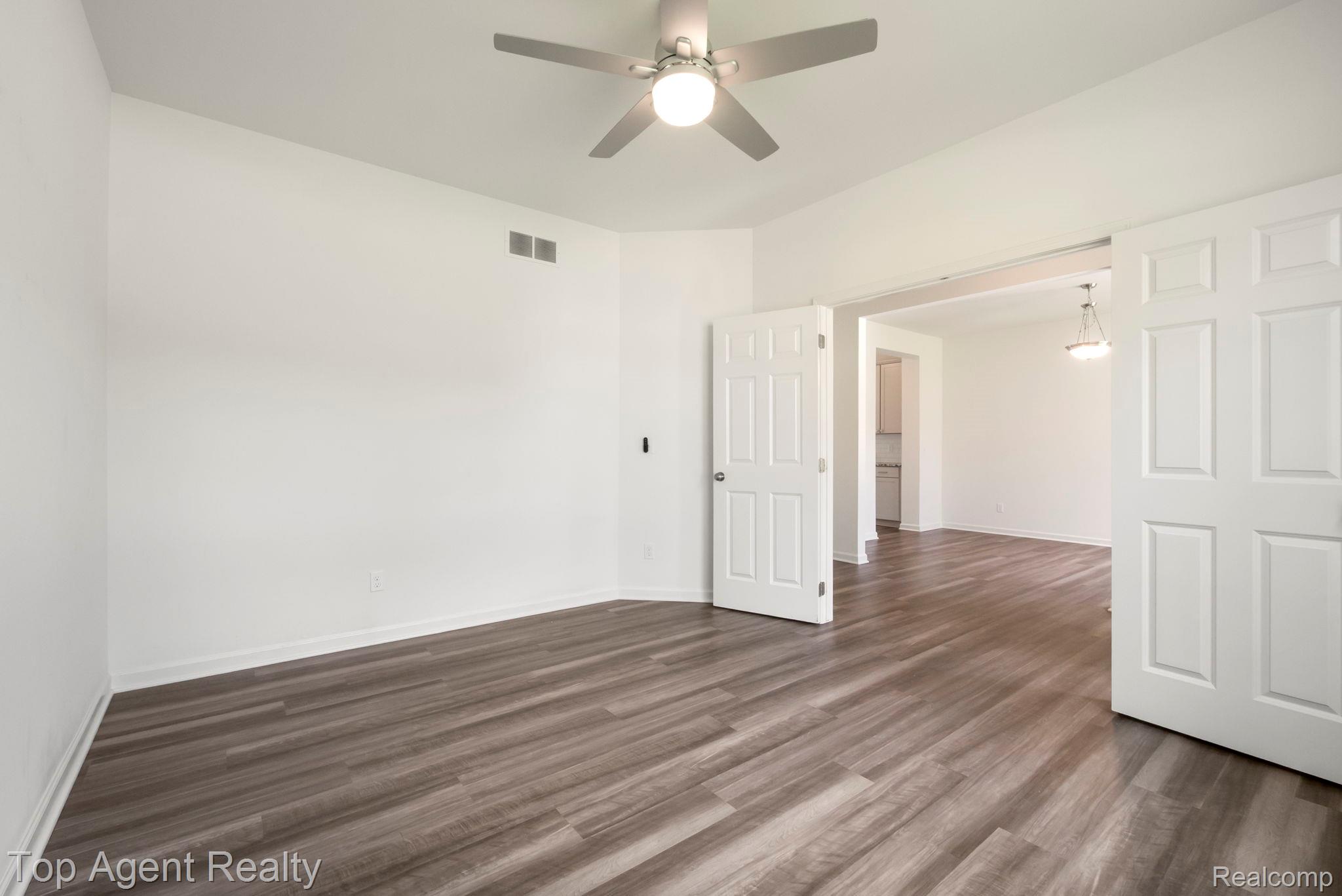 63770 Dequindre Road Washington, MI 48095 - Photo 6 of 61 Spacious room featuring wood-finish flooring, crisp white walls, and a ceiling fan with integrated lighting