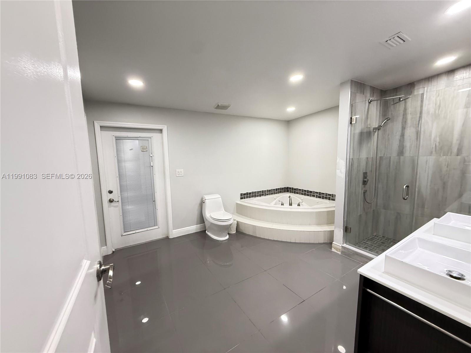 5488 Fearnley Road Lake Worth, FL 33467 - Photo 17 of 40 a spacious bathroom with a bathtub and sink