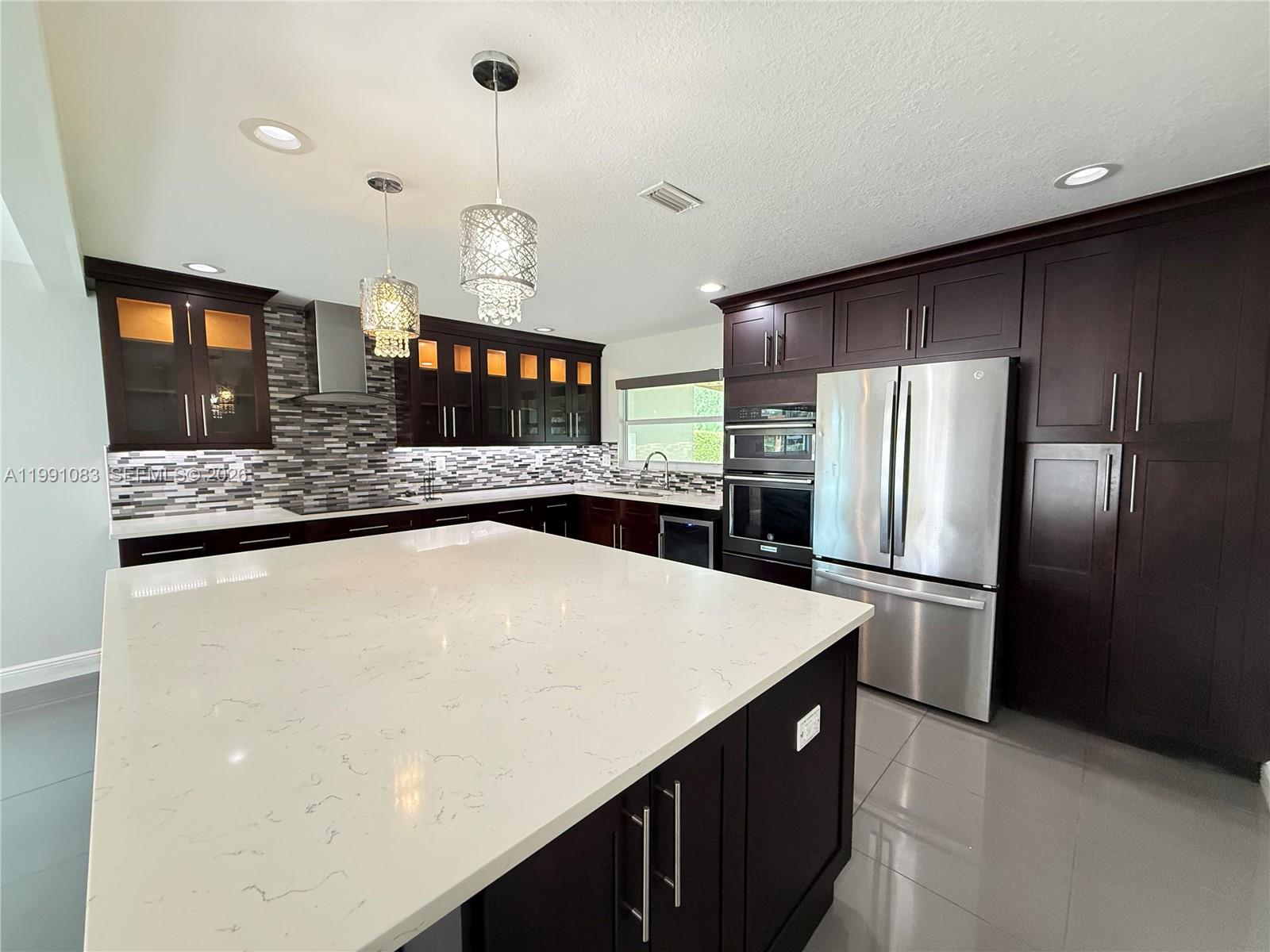 5488 Fearnley Road Lake Worth, FL 33467 - Photo 2 of 40 a kitchen with stainless steel appliances a refrigerator and a sink