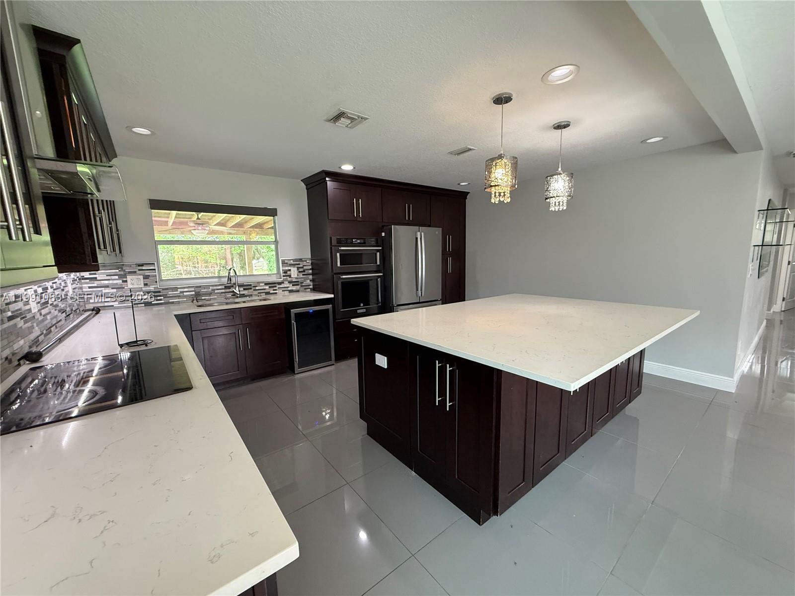 5488 Fearnley Road Lake Worth, FL 33467 - Photo 3 of 40 a kitchen with stainless steel appliances a sink stove and cabinets