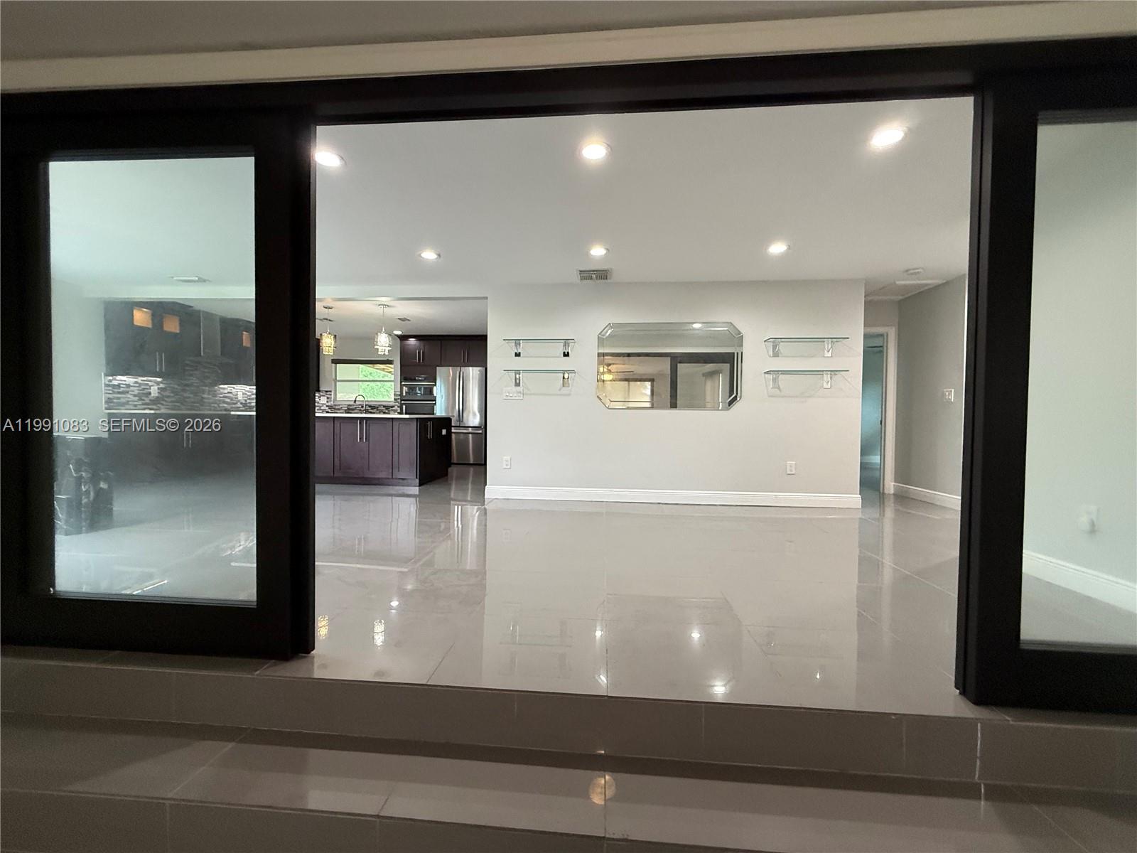 5488 Fearnley Road Lake Worth, FL 33467 - Photo 5 of 40 a view of a hallway with wooden floor and a living room