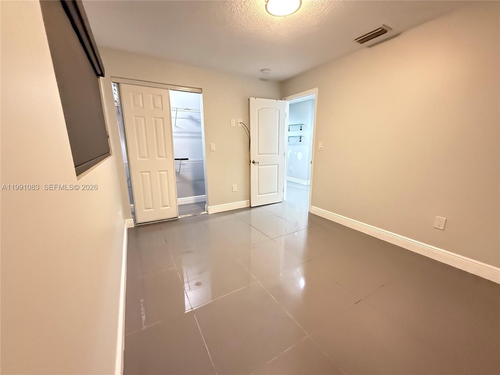 5488 Fearnley Road Lake Worth, FL 33467 - Photo 8 of 40 an empty room with wooden floor and windows