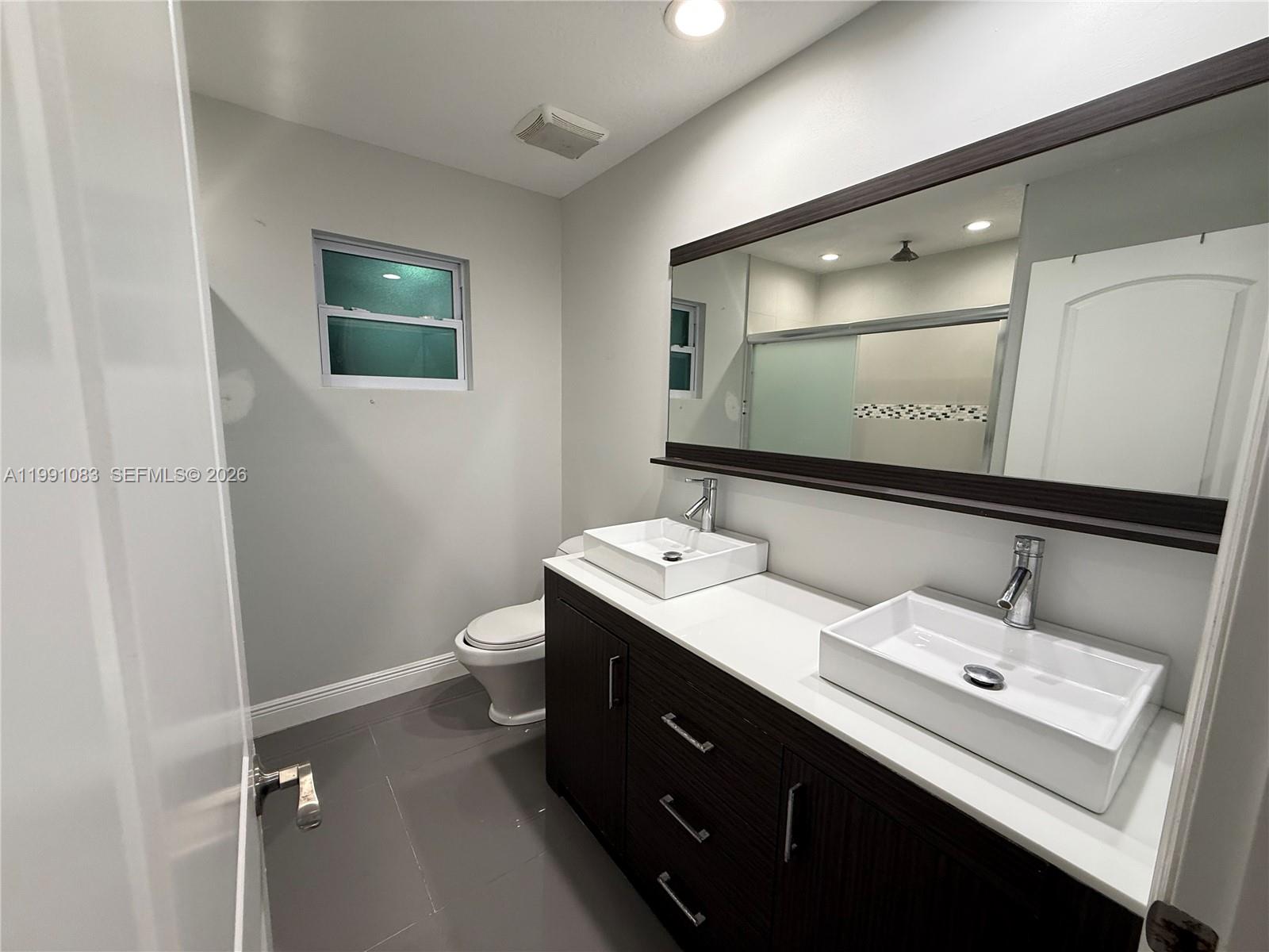 5488 Fearnley Road Lake Worth, FL 33467 - Photo 10 of 40 a bathroom with a double vanity sink and mirror