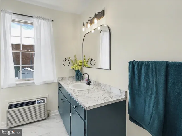 a bathroom with a granite countertop sink and a mirror