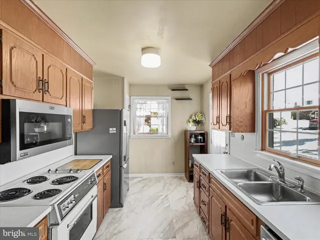 a kitchen that has a sink a stove and cabinets