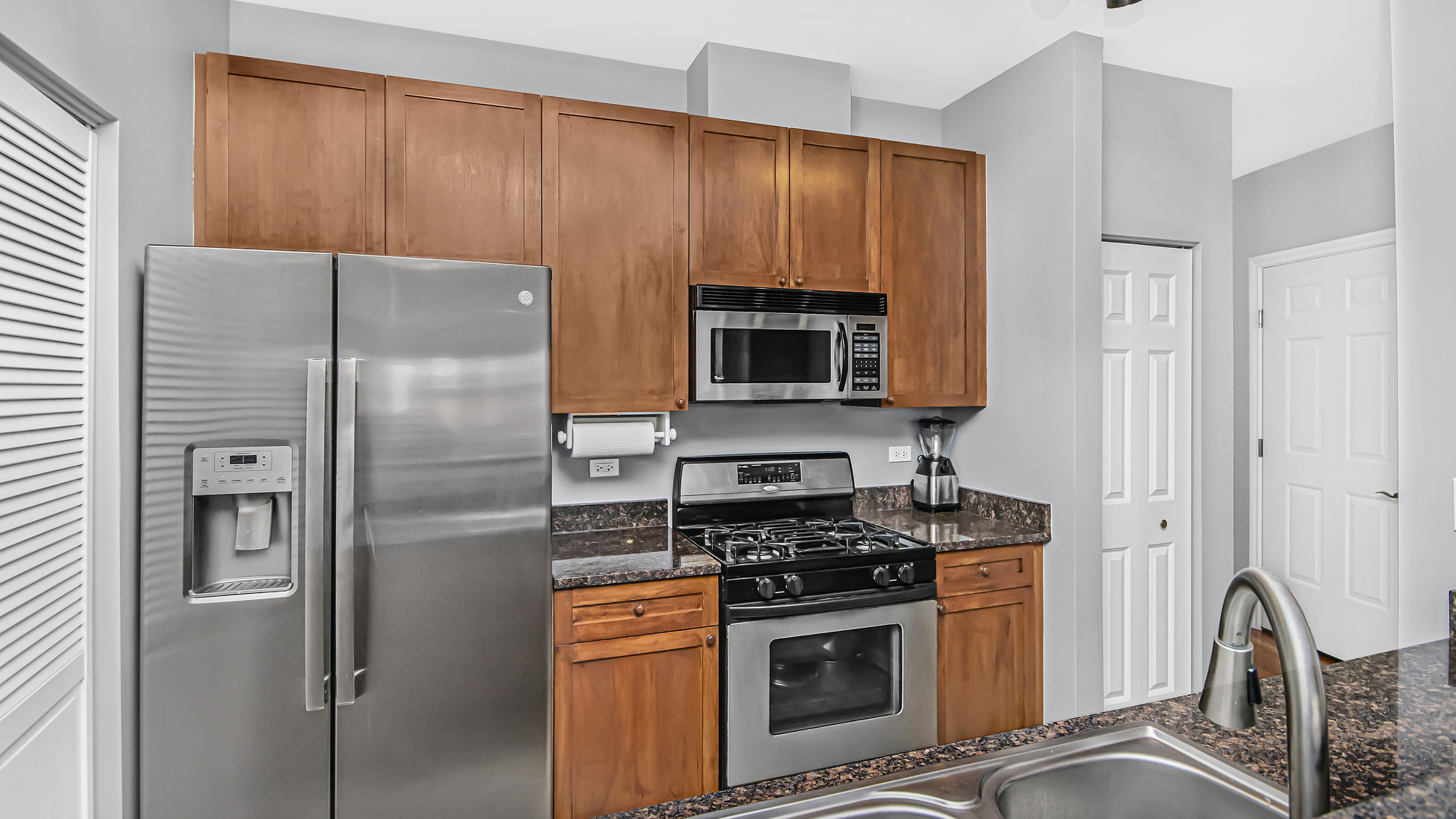 7738 North Sheridan Road, Unit 4L Chicago, IL 60626 - Photo 11 of 30 a kitchen with stainless steel appliances granite countertop a refrigerator stove and sink