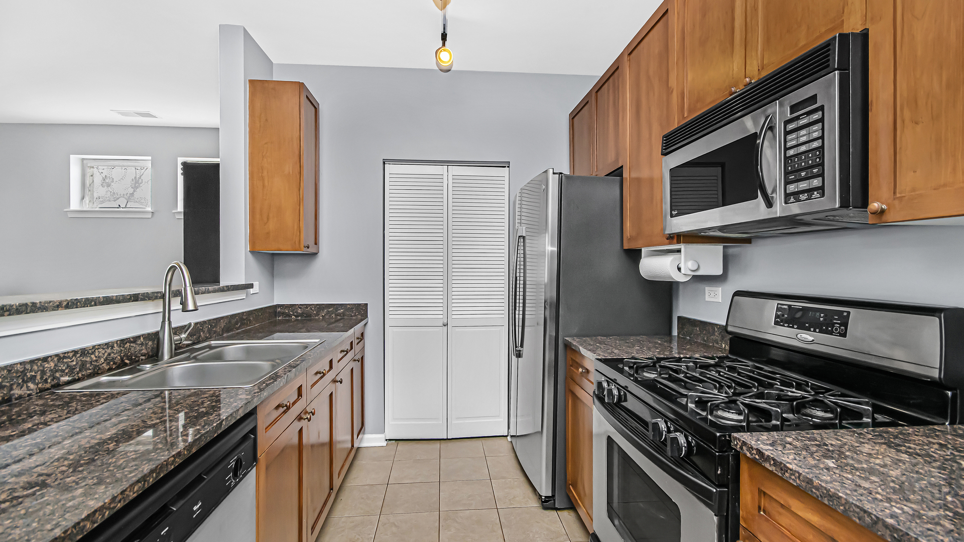 7738 North Sheridan Road, Unit 4L Chicago, IL 60626 - Photo 9 of 30 a kitchen with stainless steel appliances granite countertop a stove and a microwave