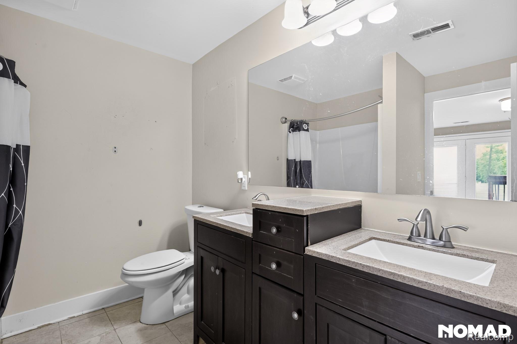 8315 Hilton Road Brighton, MI 48114 - Photo 20 of 26 Dual vanity with dark wood-finish cabinetry and light-toned countertops