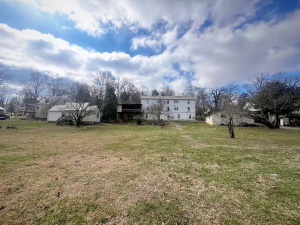 a front view of a house with a yard and trees