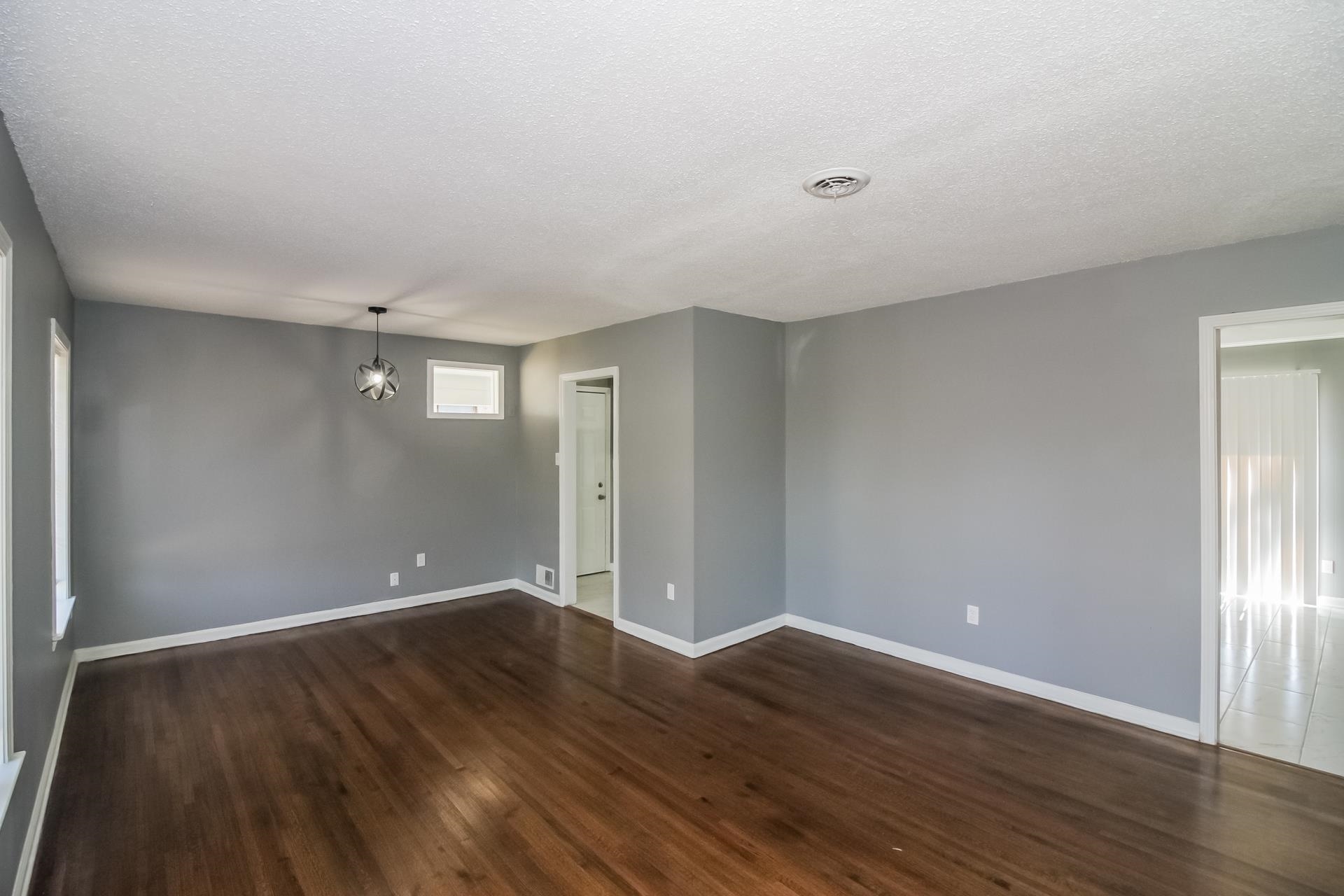 4559 Cottonwood Road Memphis, TN 38118 - Photo 5 of 16 Unfurnished room with dark wood finished floors and a textured ceiling