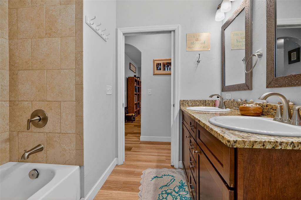 30 Deer Trail Circle Bronson, FL 32621 - Photo 20 of 55 a bathroom with a granite countertop sink a mirror a bathtub and shower