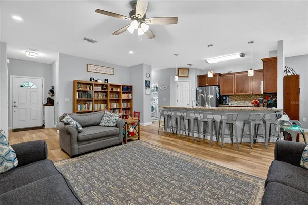 a living room with furniture a ceiling fan and a rug
