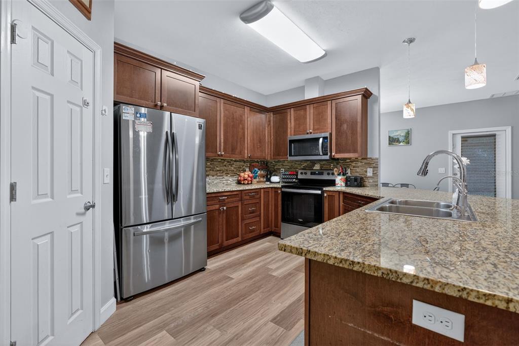 30 Deer Trail Circle Bronson, FL 32621 - Photo 10 of 55 a kitchen with granite countertop a refrigerator a sink a stove a microwave and island