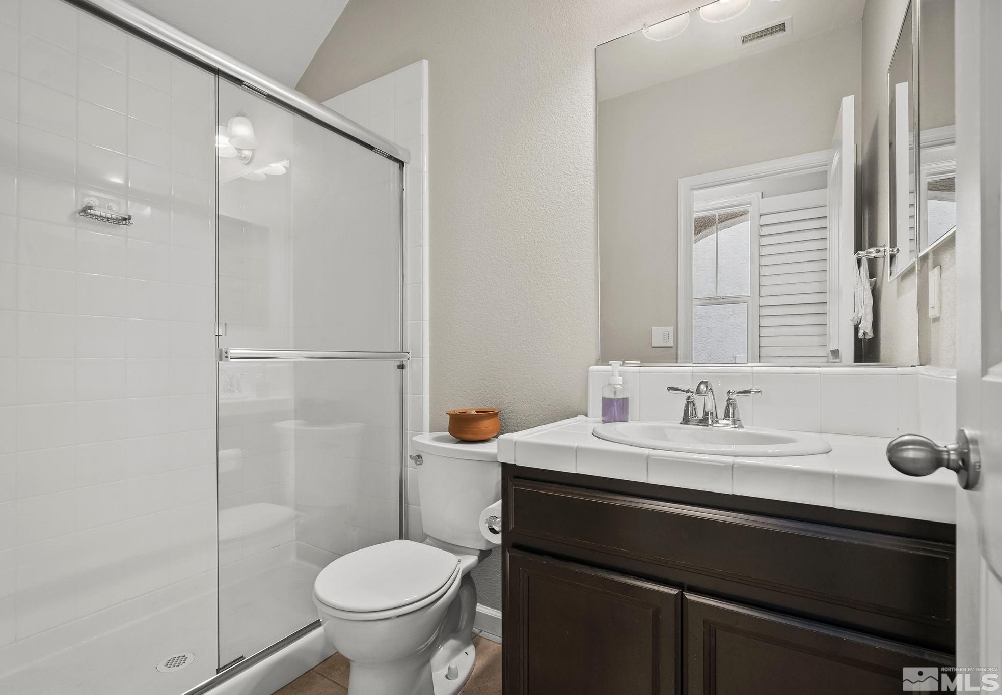 2055 Hope Valley Drive Reno, NV 89521 - Photo 15 of 21 a bathroom with a granite countertop sink toilet a mirror and shower