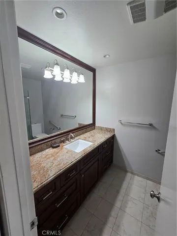 a bathroom with a granite countertop sink and a mirror