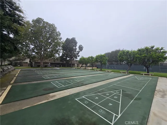 a view of a tennis ground with large trees