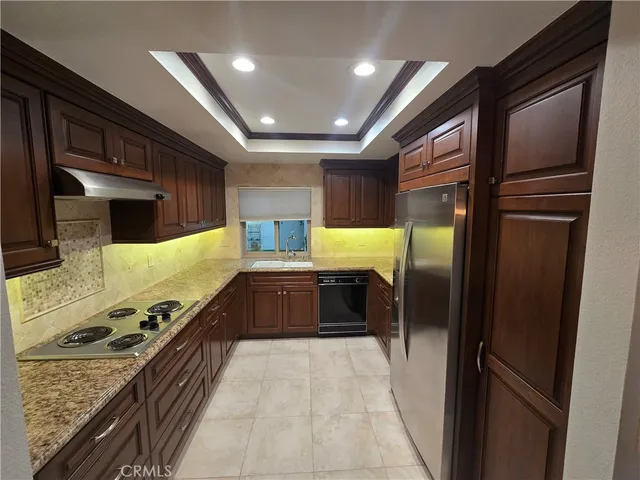 a large kitchen with stainless steel appliances granite countertop a refrigerator and a stove