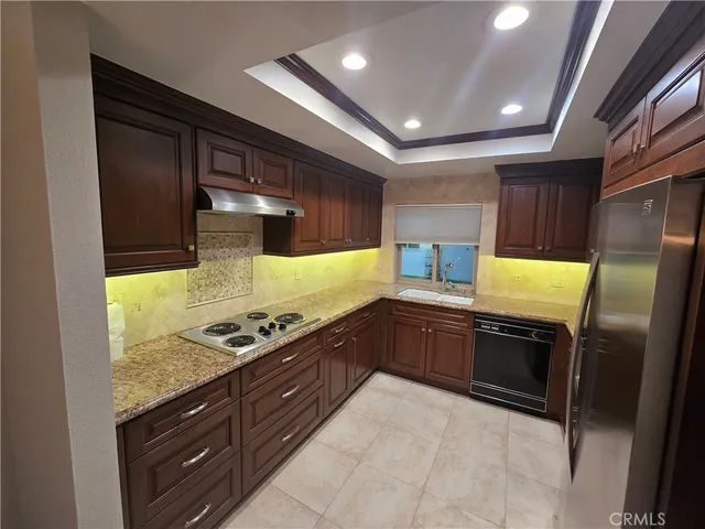 a kitchen with stainless steel appliances granite countertop a stove a sink and a refrigerator