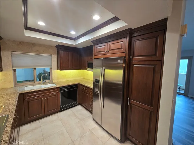 a kitchen with stainless steel appliances granite countertop a refrigerator and a sink