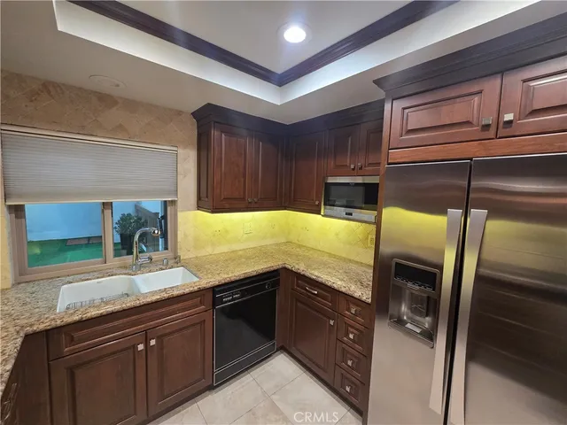 a kitchen with granite countertop stainless steel appliances and wooden cabinets