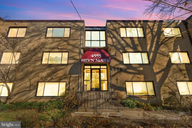 a front view of a residential apartment building with a yard