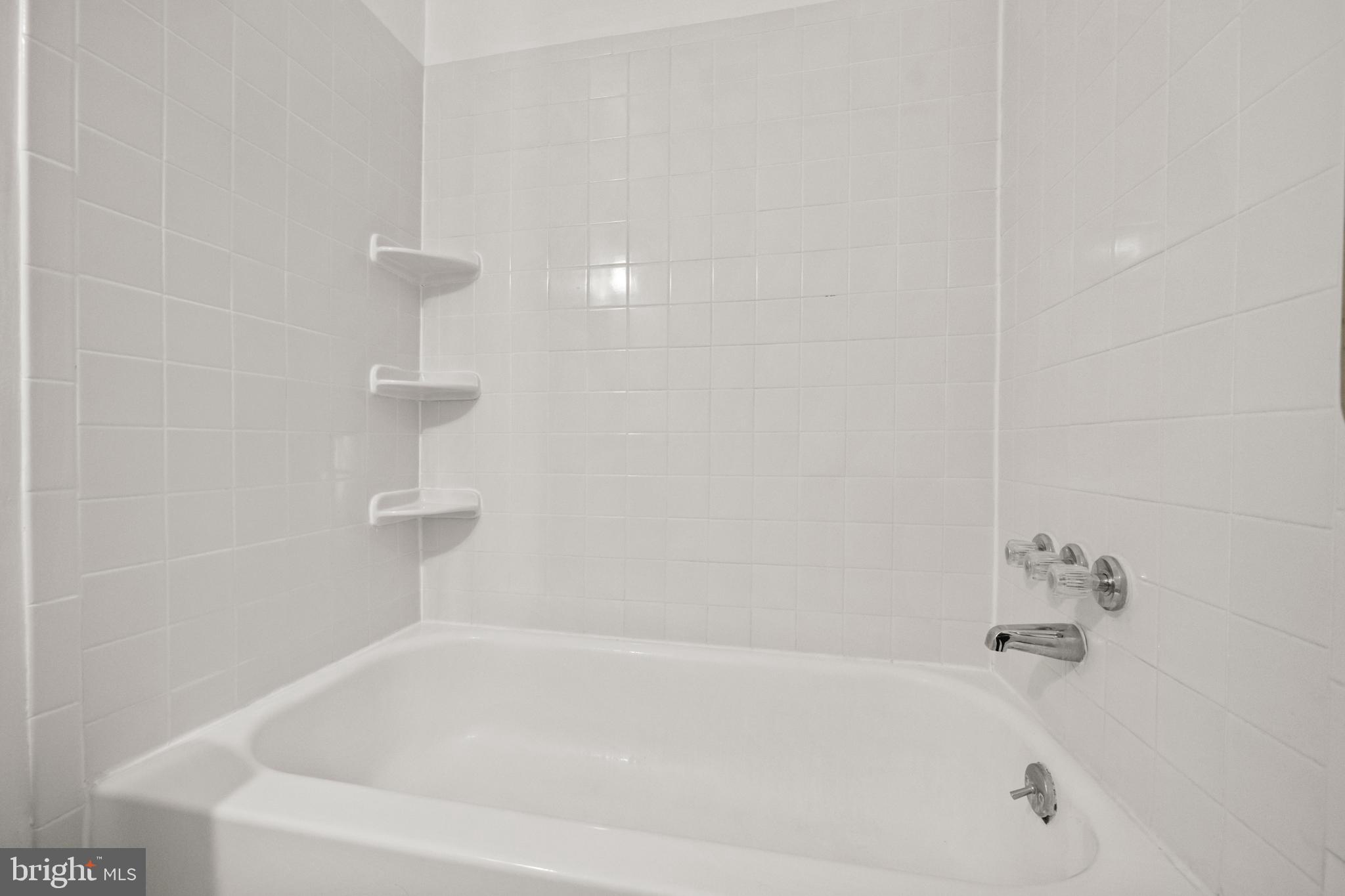 4555 MacArthur Boulevard Northwest, Unit 202 Washington, DC 20007 - Photo 19 of 27 a white bath tub sitting in a bathroom