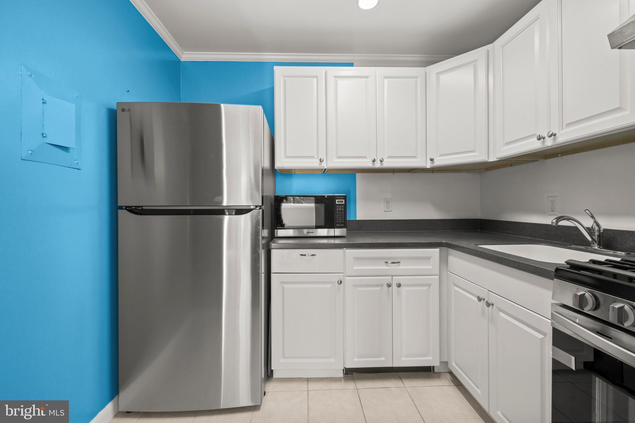 4555 MacArthur Boulevard Northwest, Unit 202 Washington, DC 20007 - Photo 7 of 27 a kitchen with white cabinets and refrigerator
