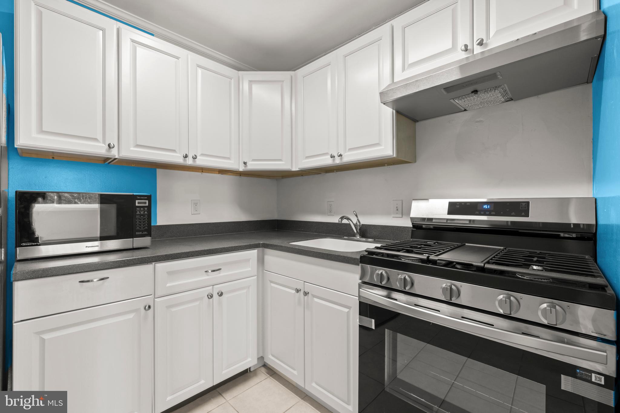 4555 MacArthur Boulevard Northwest, Unit 202 Washington, DC 20007 - Photo 8 of 27 a kitchen with white cabinets and appliances