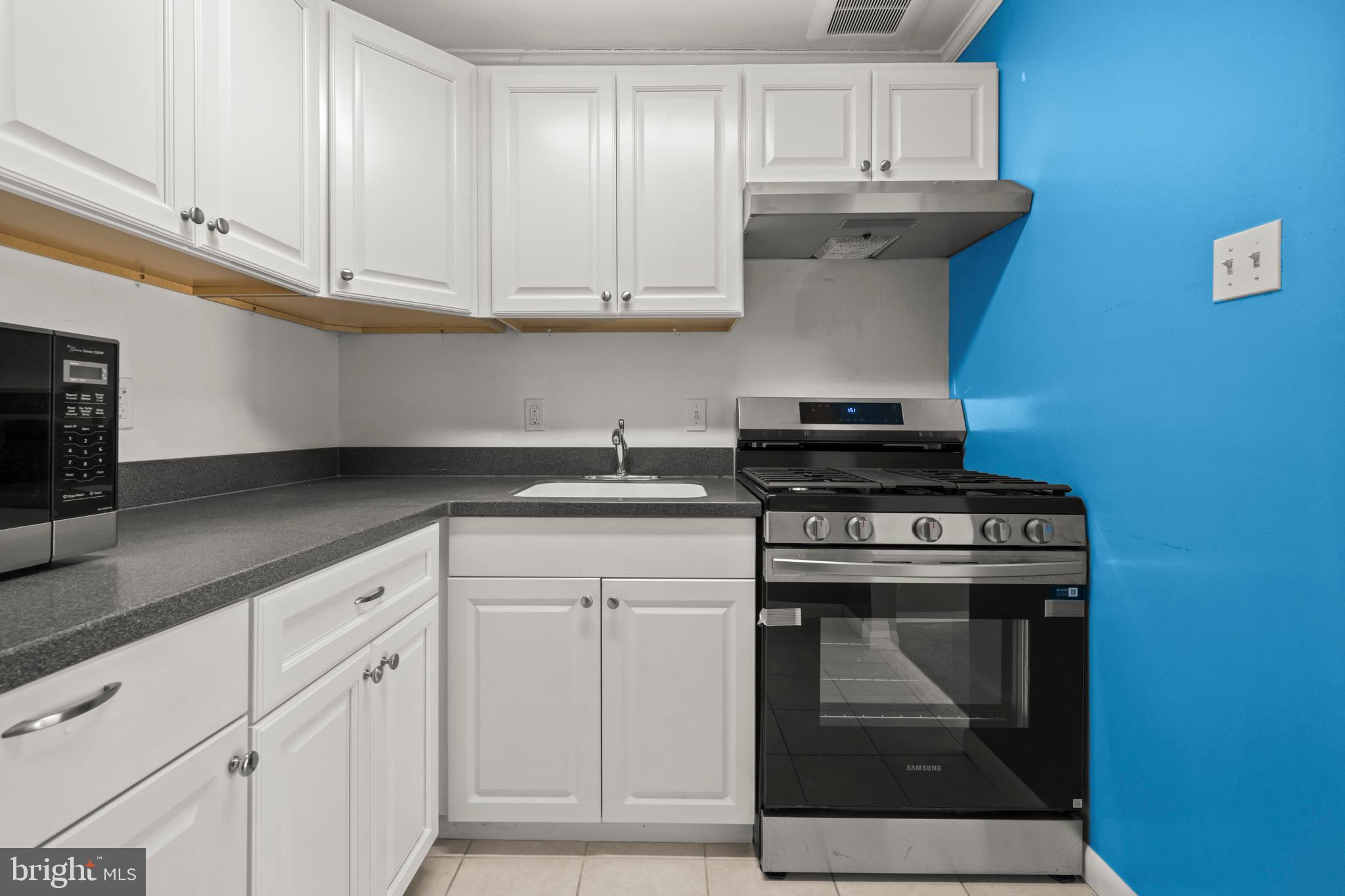 4555 MacArthur Boulevard Northwest, Unit 202 Washington, DC 20007 - Photo 9 of 27 a kitchen with granite countertop white cabinets and stainless steel appliances
