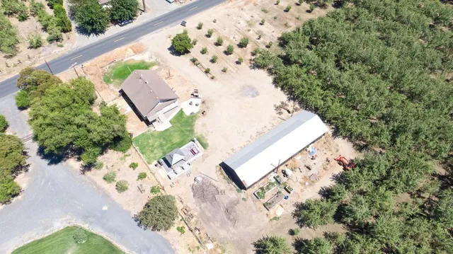 an aerial view of a house with a yard and trees