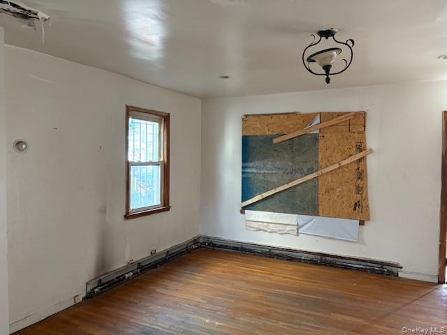 114-06 167th Street Queens, NY 11434 - Photo 16 of 23 Spare room with wood finished floors and a baseboard heating unit
