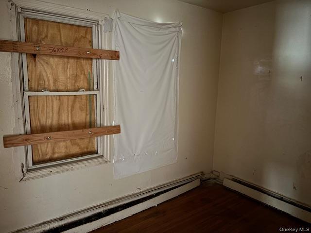114-06 167th Street Queens, NY 11434 - Photo 17 of 23 Unfurnished room with a baseboard radiator and dark wood-type flooring