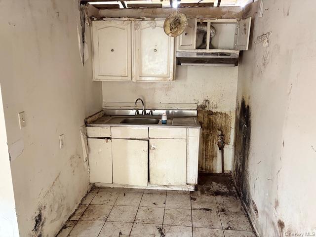 114-06 167th Street Queens, NY 11434 - Photo 3 of 23 Kitchen with white cabinetry, under cabinet range hood, and tile countertops