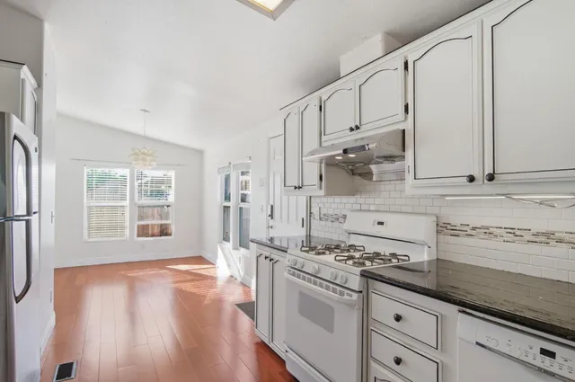 a kitchen with stainless steel appliances a sink stove and cabinets
