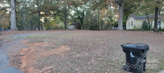 a view of a backyard with large trees