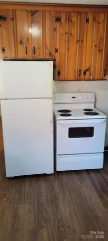 a view of front door with hallway and wooden floor