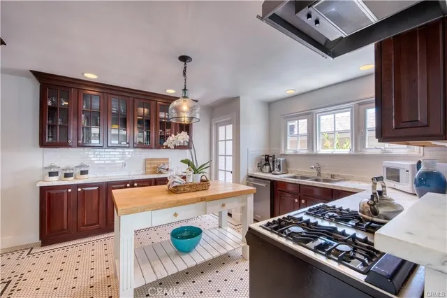 a kitchen with stainless steel appliances a stove a sink dishwasher and cabinets with wooden floor