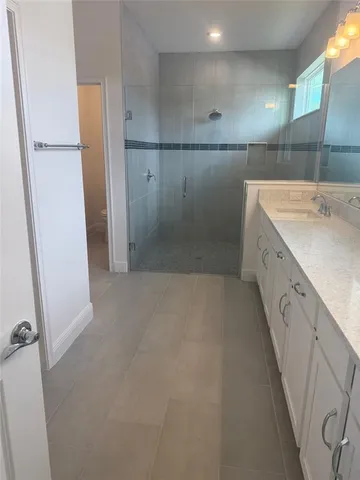 a bathroom with a granite countertop sink a toilet and shower