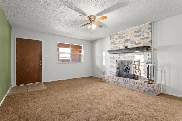an empty room with windows and fireplace