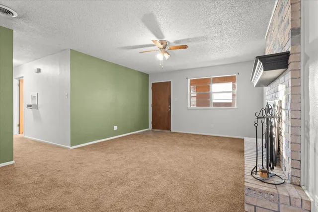 an empty room with fan and windows