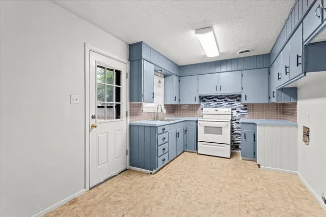 a kitchen with white cabinets and white appliances