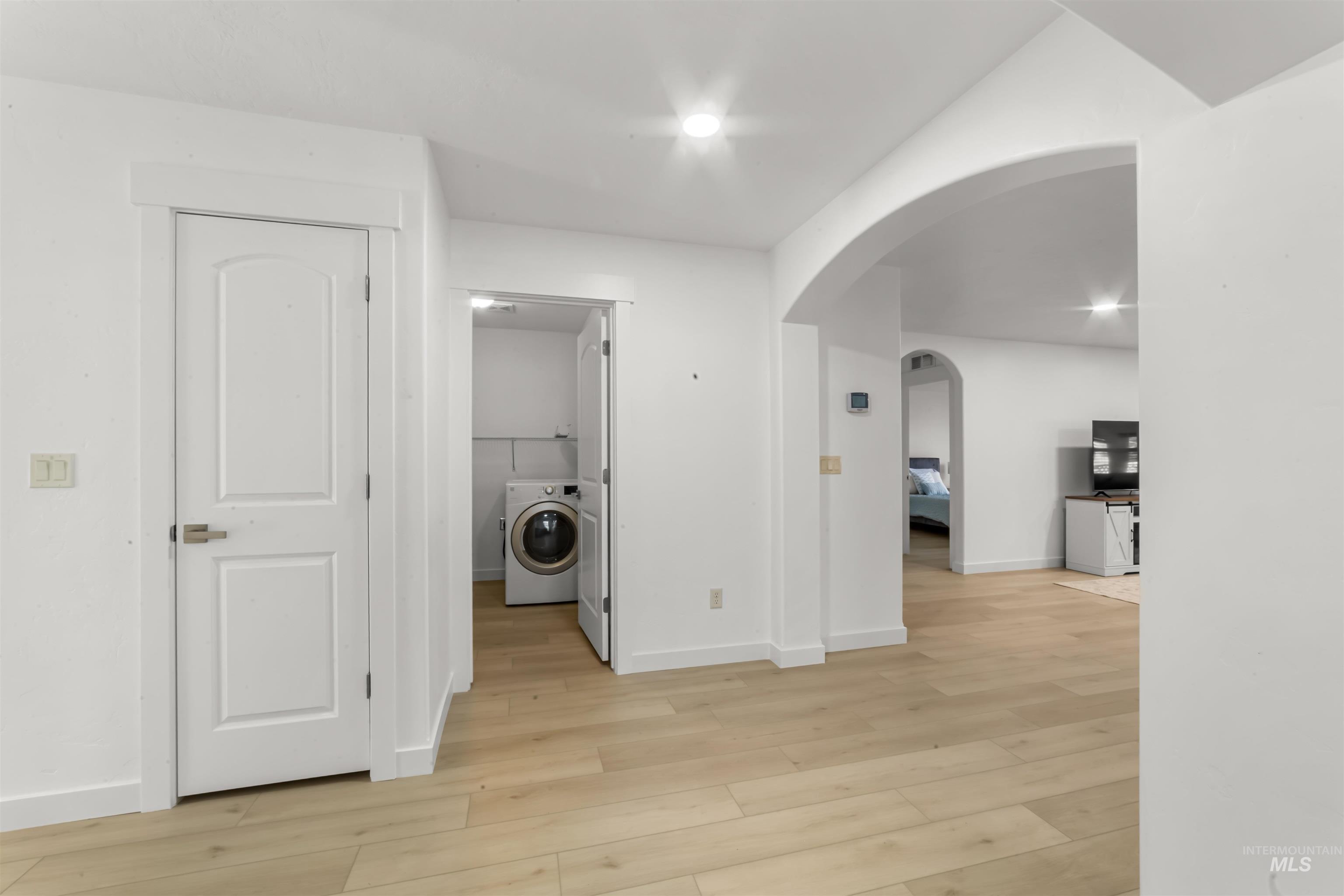 548 North Ripplerock Place Star, ID 83669 - Photo 18 of 42 Laundry room with washer / clothes dryer, arched walkways, and light wood-style flooring