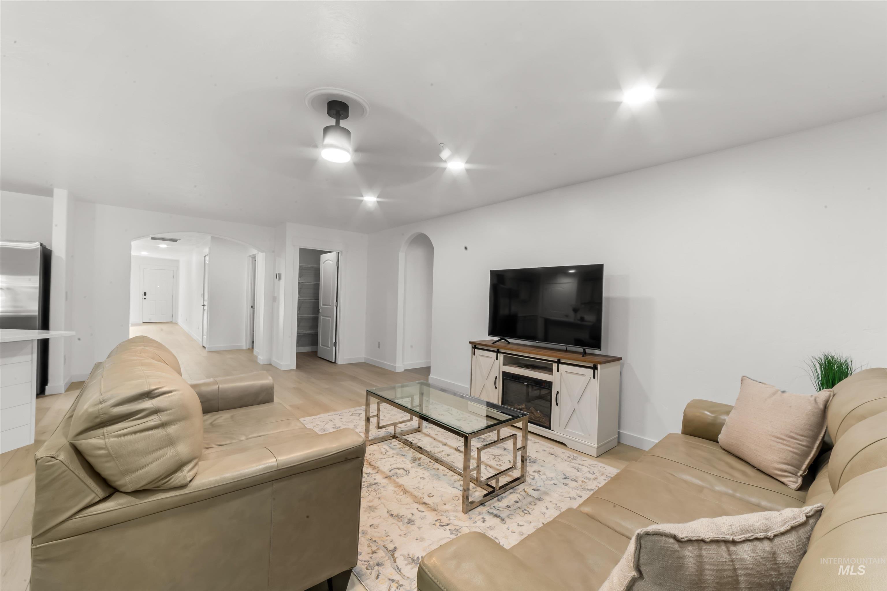 548 North Ripplerock Place Star, ID 83669 - Photo 23 of 42 Living room with arched walkways, ceiling fan, and light wood-style flooring