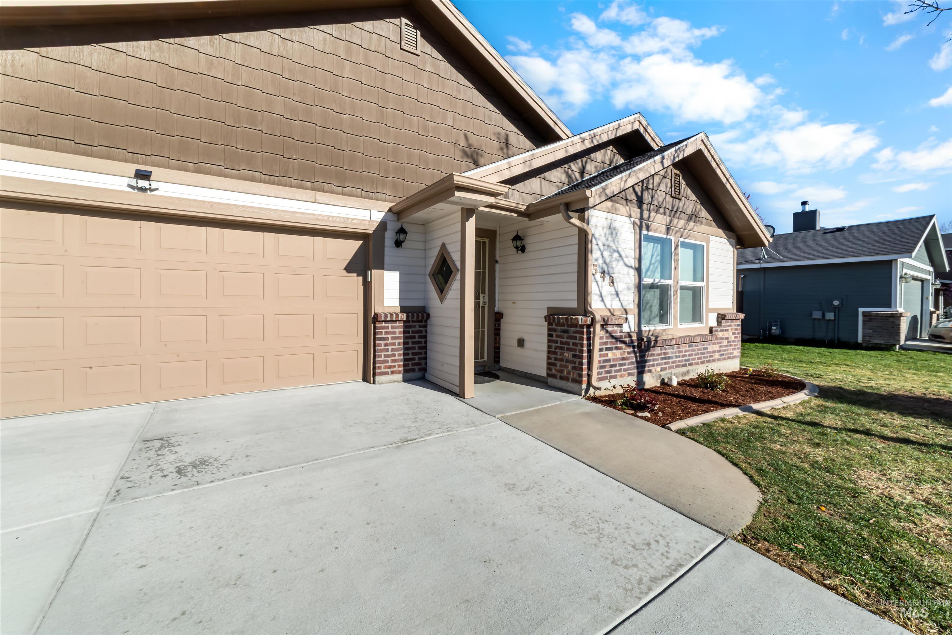 548 North Ripplerock Place Star, ID 83669 - Photo 3 of 42 View of front of house with brick siding, concrete driveway, and a front yard