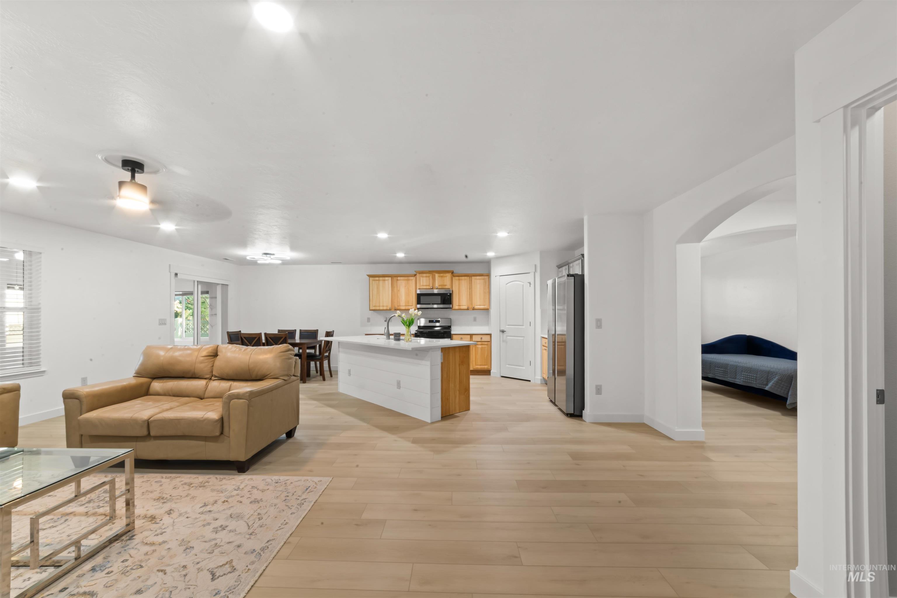 548 North Ripplerock Place Star, ID 83669 - Photo 33 of 42 Living area featuring recessed lighting, light wood finished floors, arched walkways, and a ceiling fan