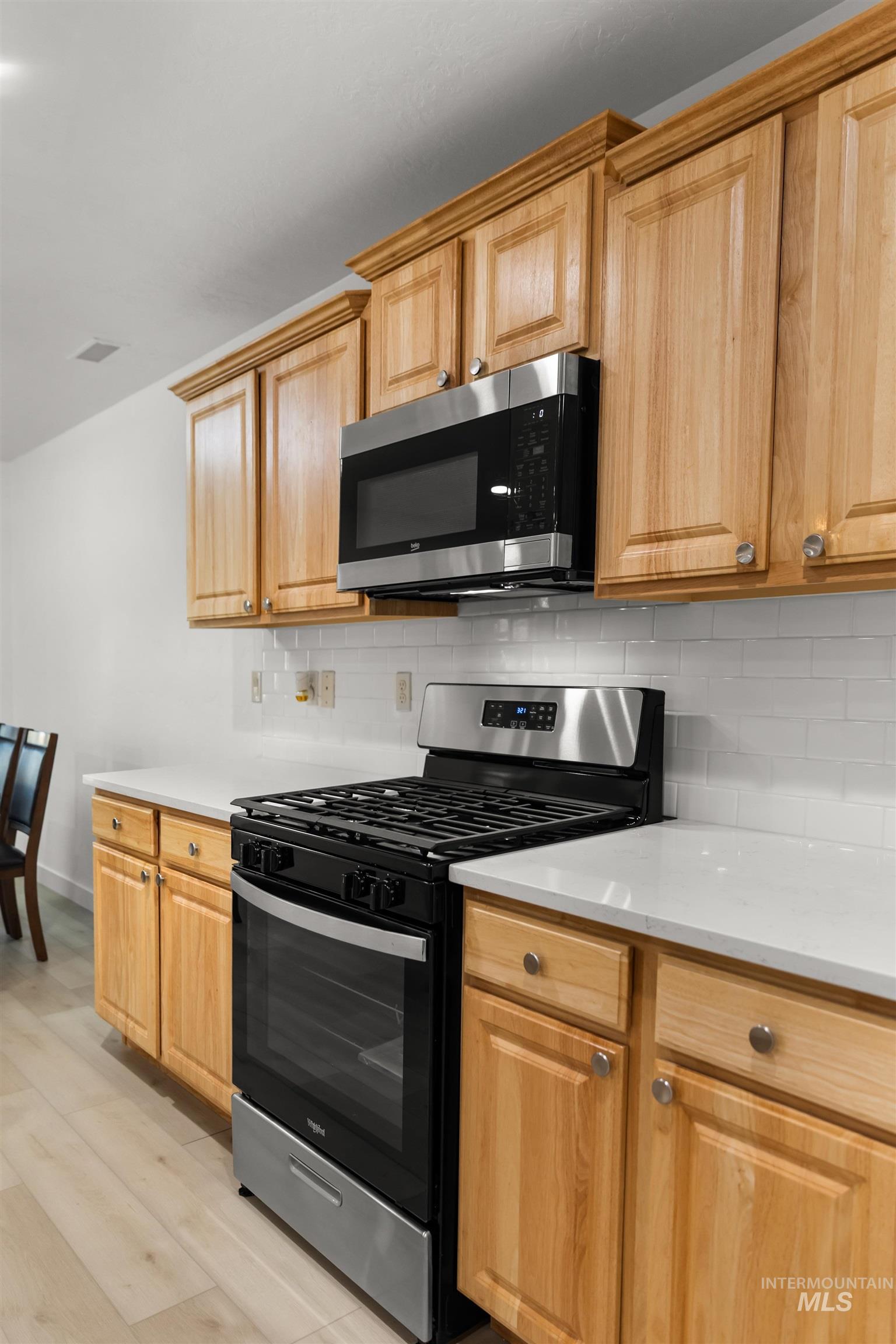 548 North Ripplerock Place Star, ID 83669 - Photo 38 of 42 Kitchen with stainless steel appliances, light wood-style flooring, and tasteful backsplash