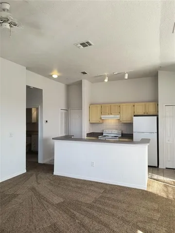 a large kitchen with a large counter top and stainless steel appliances