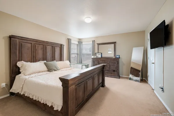 a bed room with a bed a television and dresser