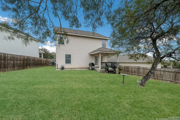 a view of a house with backyard and a tree