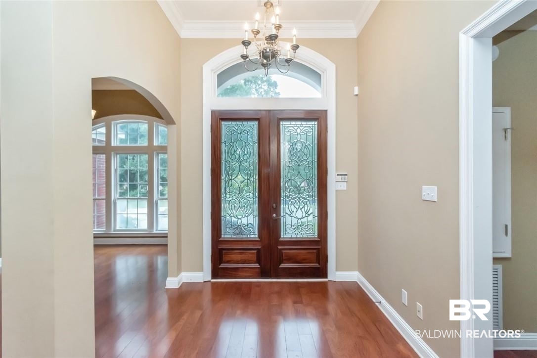 8837 Dawes Lake Road South Mobile, AL 36619 - Photo 4 of 44 Entrance foyer with crown molding, french doors, a notable chandelier, and dark hardwood / wood-style floors